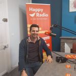 Un homme assis à une table devant un microphone
